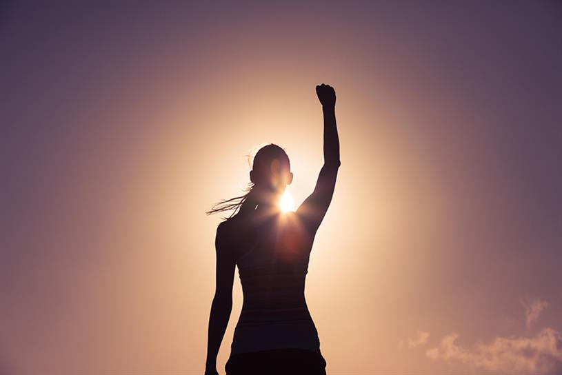 Woman raising her arm in silhouette